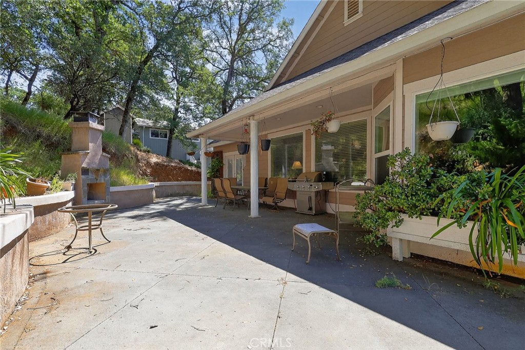 19370 Park Ridge Drive Hidden Valley Lake, CA 95467 - Photo 48 of 61 a view of a patio with table and chairs potted plants and a large tree