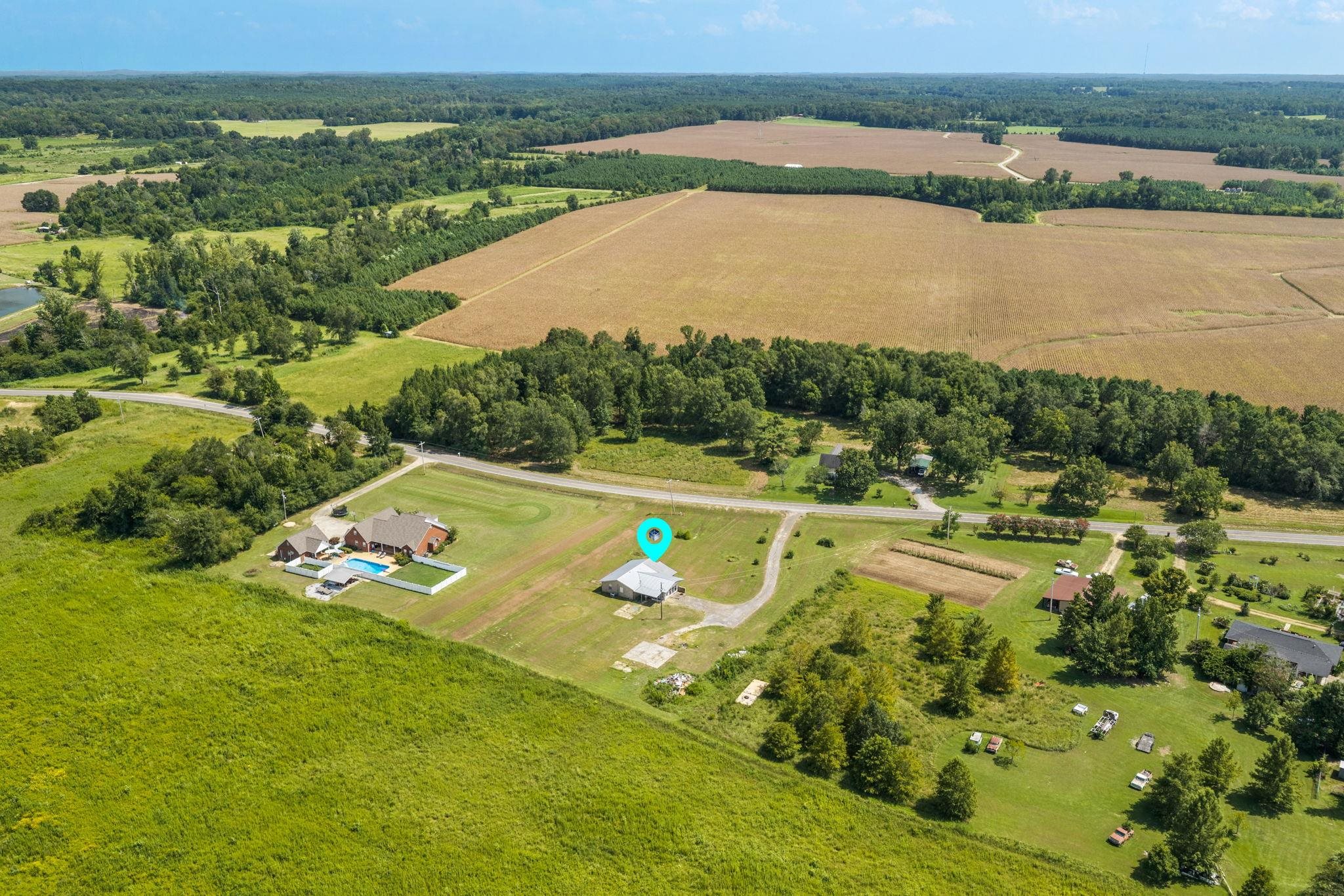 60116 Seminole Road Smithville, MS 38870 - Photo 36 of 38 Expansive rural landscape featuring a large agricultural field, wooded areas, and a paved road