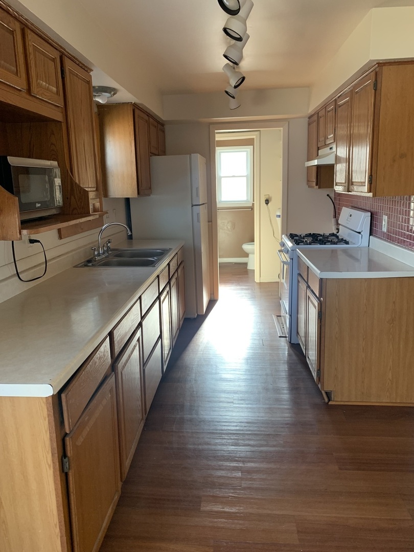 3637 Morgan Street Steger, IL 60475 - Photo 2 of 9 a kitchen with stainless steel appliances granite countertop a sink a stove and a wooden floors