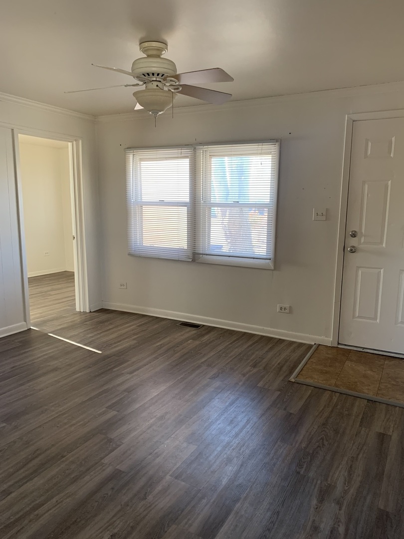 3637 Morgan Street Steger, IL 60475 - Photo 4 of 9 an empty room with wooden floor and windows
