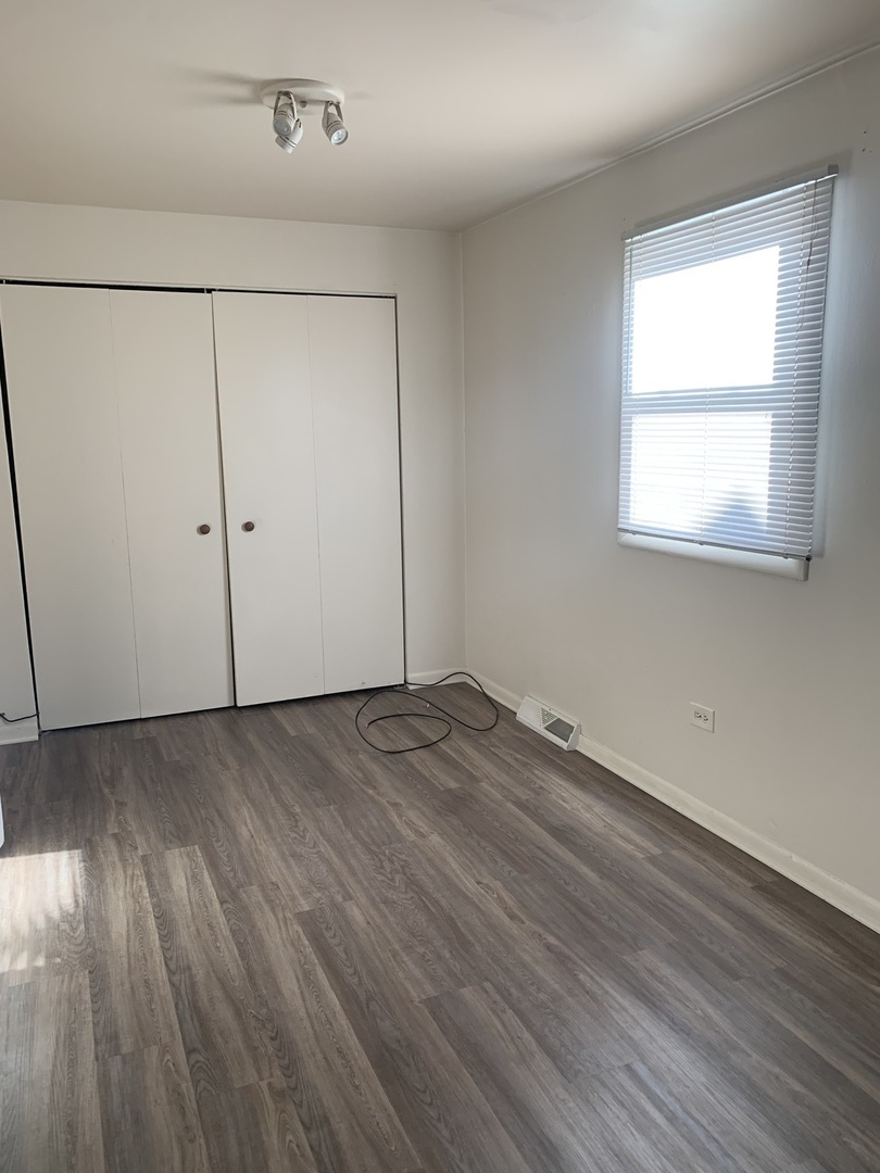 3637 Morgan Street Steger, IL 60475 - Photo 5 of 9 an empty room with wooden floor and windows