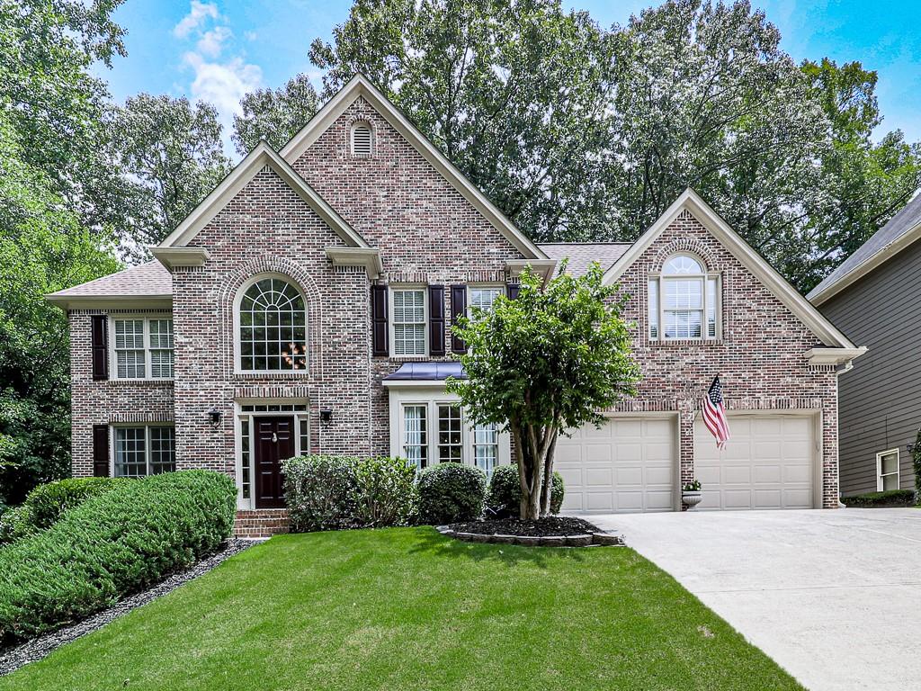 8036 Ridge Valley Woodstock, GA 30189 - Photo 1 of 1 a front view of a house with a yard and garage