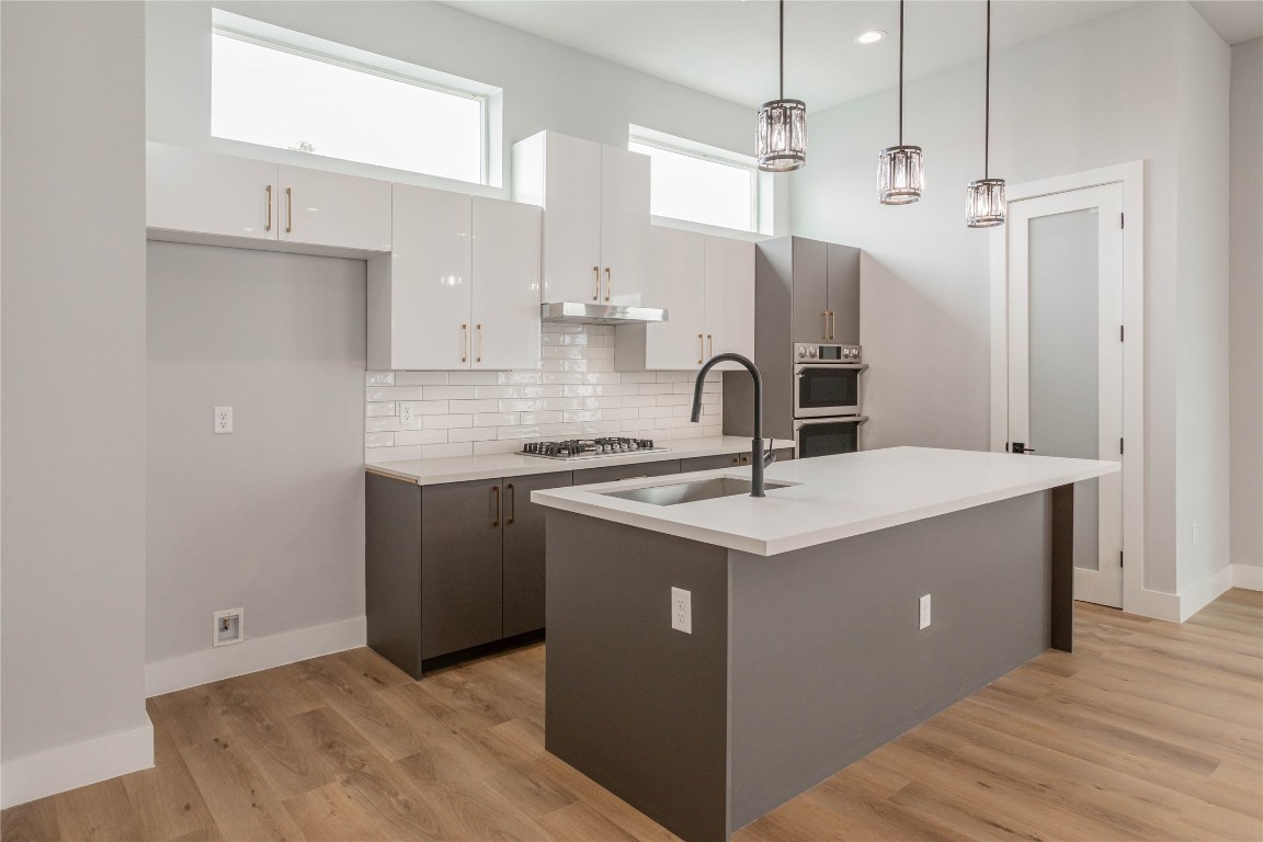 711 Boundary Street Houston, TX 77009 - Photo 11 of 26 a kitchen with a sink a stove a refrigerator and white cabinets