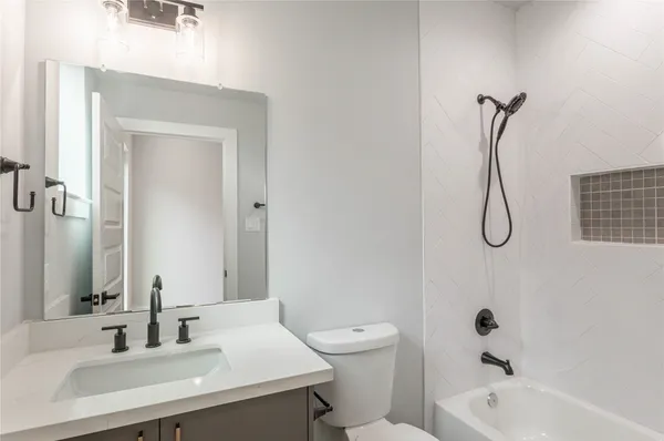 a bathroom with a sink vanity tub and a toilet