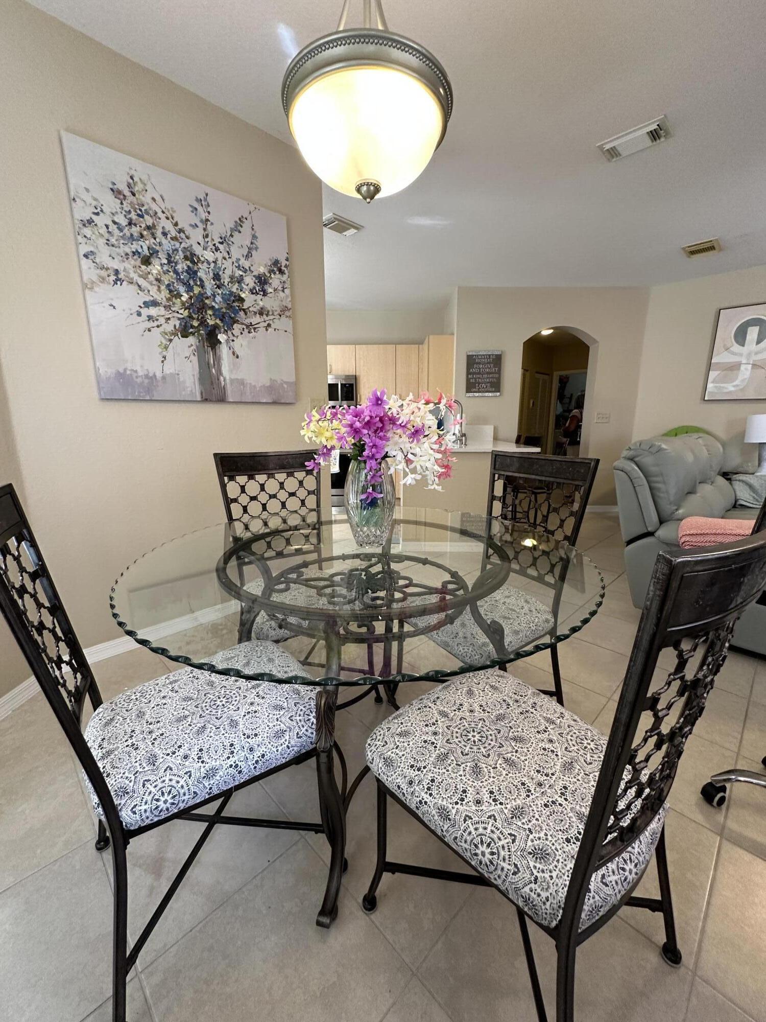 112 Southwest Peacock Boulevard, Unit 7202 Port St. Lucie, FL 34986 - Photo 5 of 11 a dining room with furniture and a wooden floor