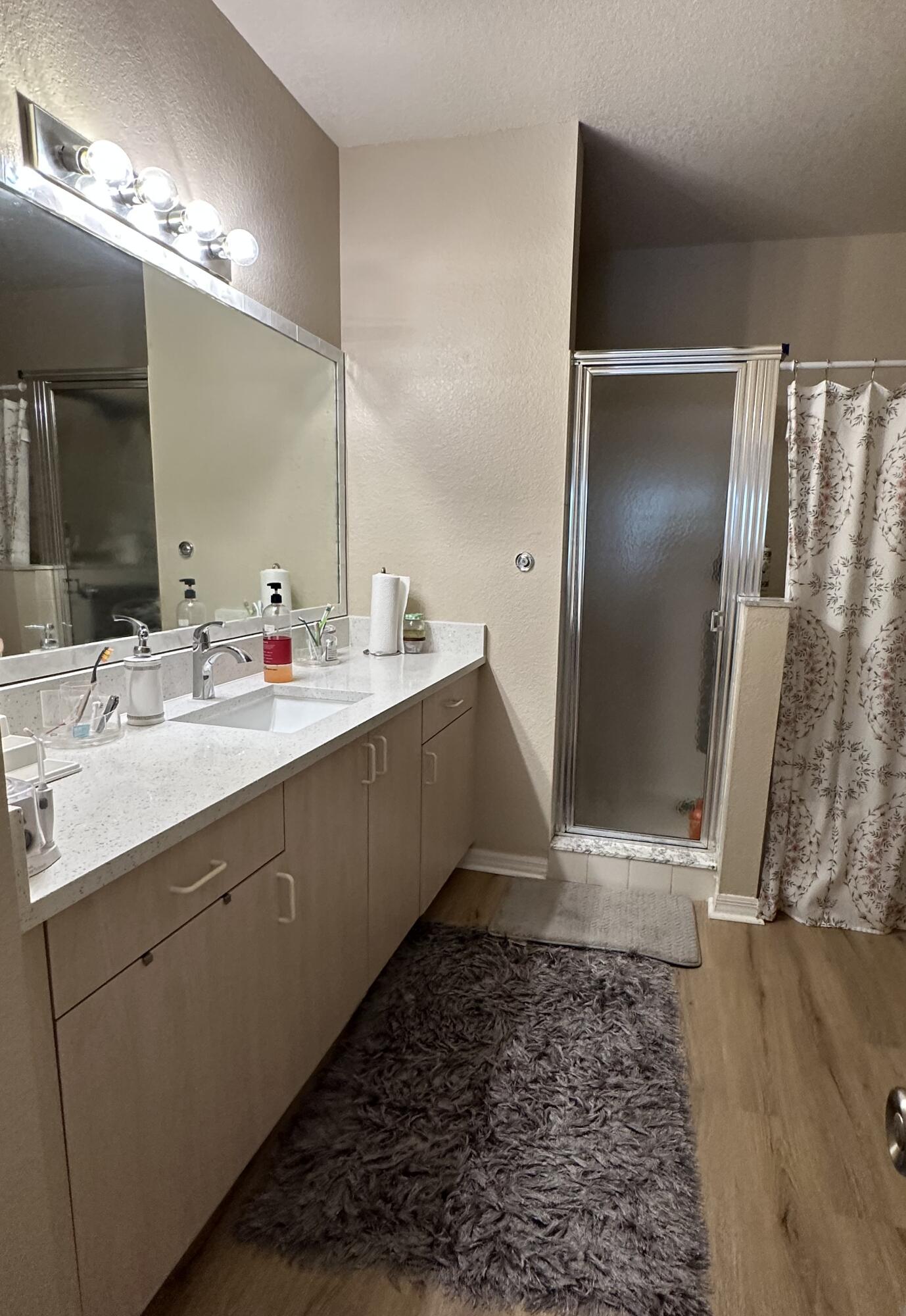 112 Southwest Peacock Boulevard, Unit 7202 Port St. Lucie, FL 34986 - Photo 8 of 11 a bathroom with a double vanity sink mirror and shower
