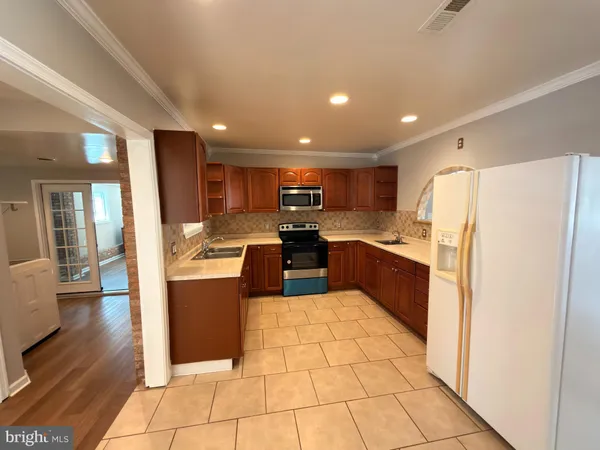 a kitchen with stainless steel appliances granite countertop a refrigerator and a stove top oven