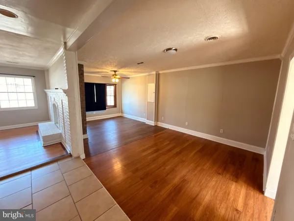 an empty room with wooden floor and fireplace
