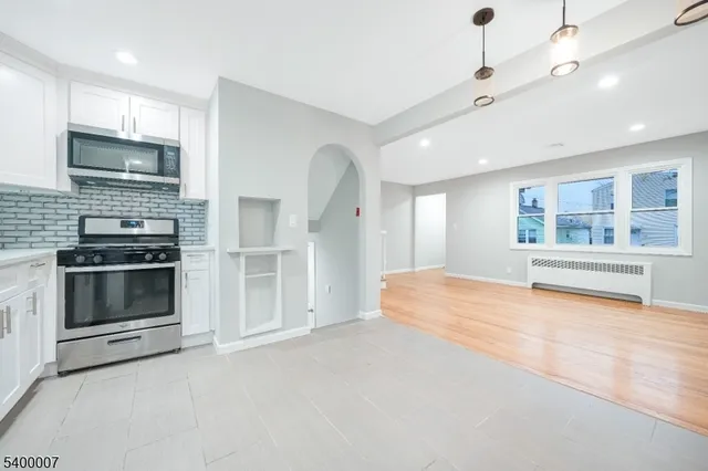 a large kitchen with stainless steel appliances granite countertop a stove and a refrigerator