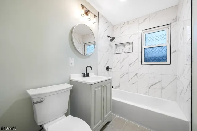 a bathroom with a sink mirror vanity and toilet