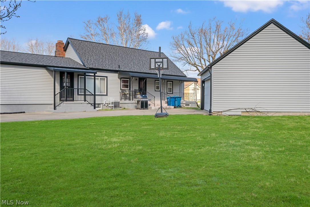 4001 South Cleveland Massillon Road Barberton, OH 44203 - Photo 14 of 25 Rear view of house featuring a yard and a shingled roof
