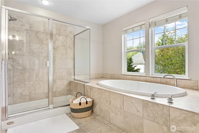 a bathroom with a granite countertop bathtub and a shower