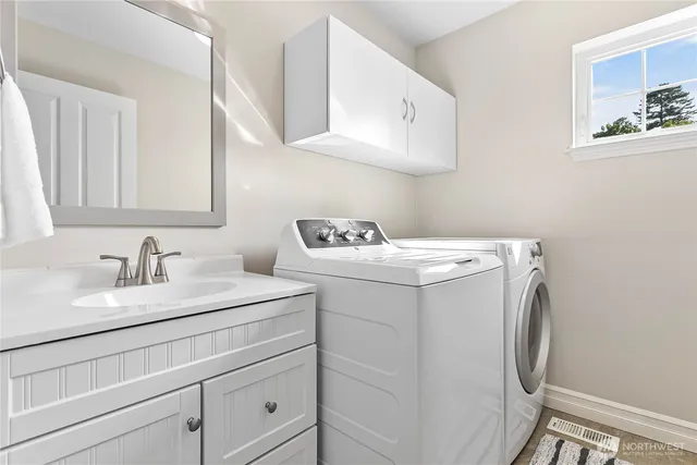 a utility room with sink dryer and washer