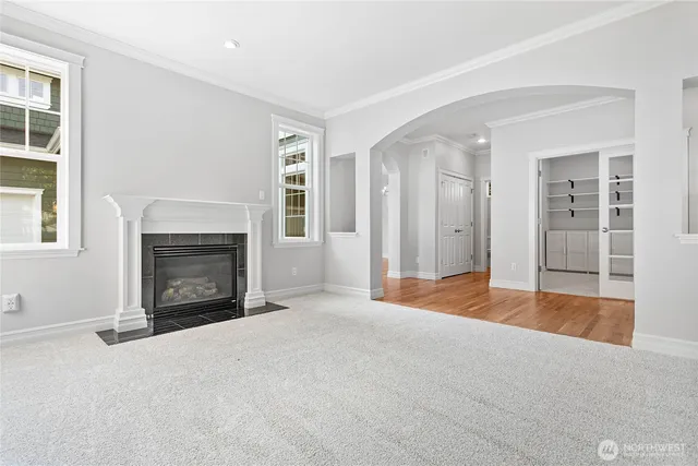 an empty room with windows and fireplace