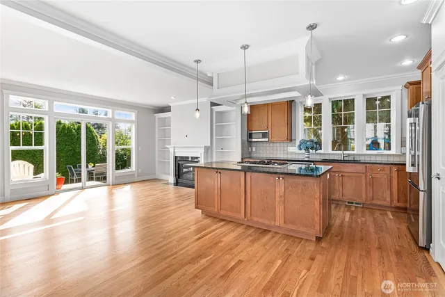 a large kitchen with granite countertop a large window and stainless steel appliances