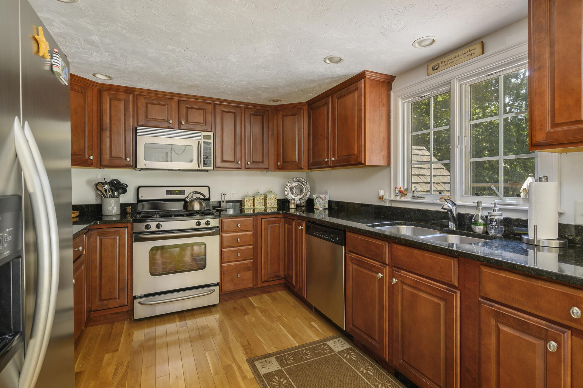63 Fuller Road Centerville, MA 02632 - Photo 7 of 17 a kitchen with granite countertop wooden cabinets stainless steel appliances a sink and a window