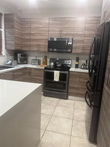 a kitchen with a refrigerator and a stove