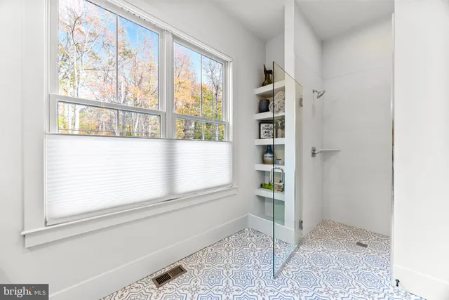 a spacious bathroom with a shower sink and mirror