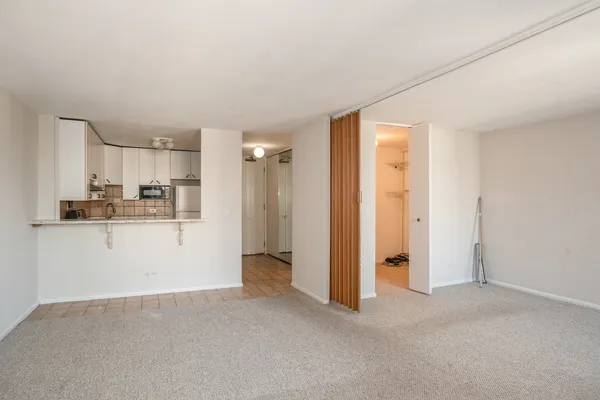a view of a kitchen with refrigerator and white cabinets
