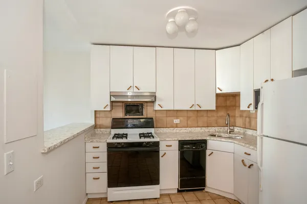 a kitchen with kitchen island sink refrigerator and stove