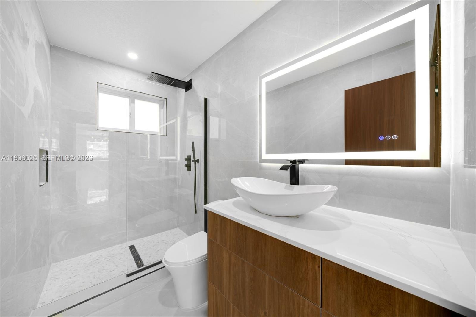 2356 Southwest 24th Street Miami, FL 33145 - Photo 22 of 36 a bathroom with a sink a toilet and shower