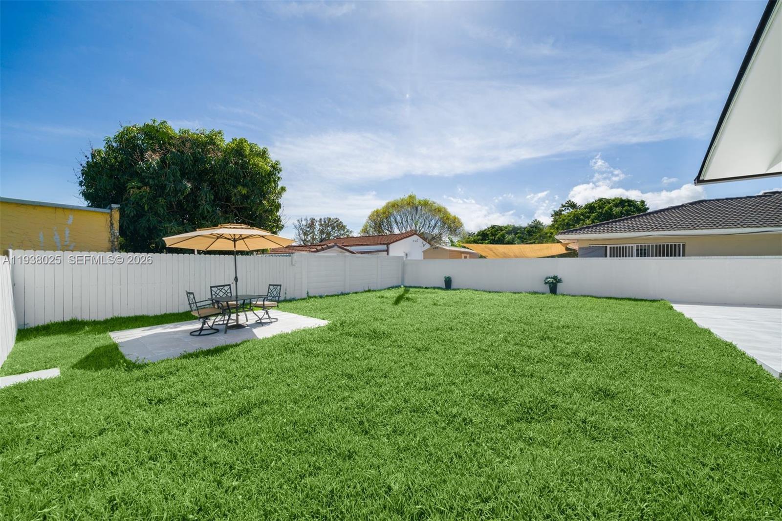 2356 Southwest 24th Street Miami, FL 33145 - Photo 33 of 36 a view of a backyard with lawn chairs under an umbrella