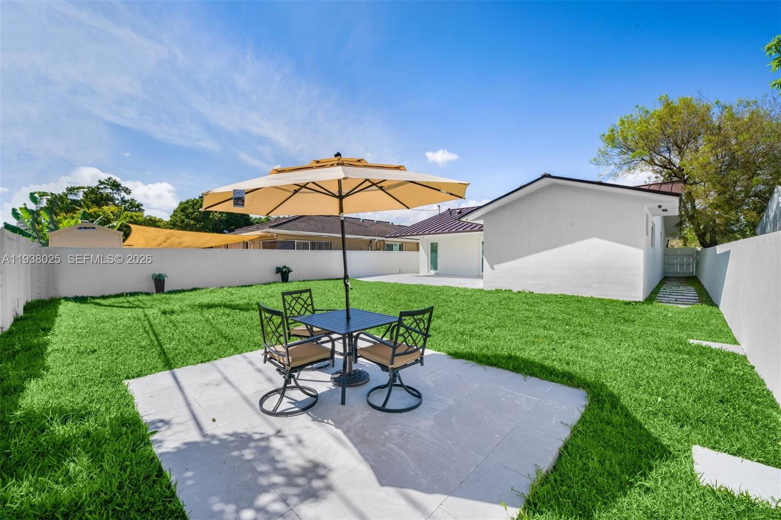 2356 Southwest 24th Street Miami, FL 33145 - Photo 34 of 36 a view of a yard with a table and chairs under an umbrella
