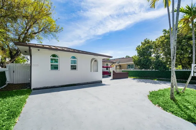 a view of a house with backyard and tree