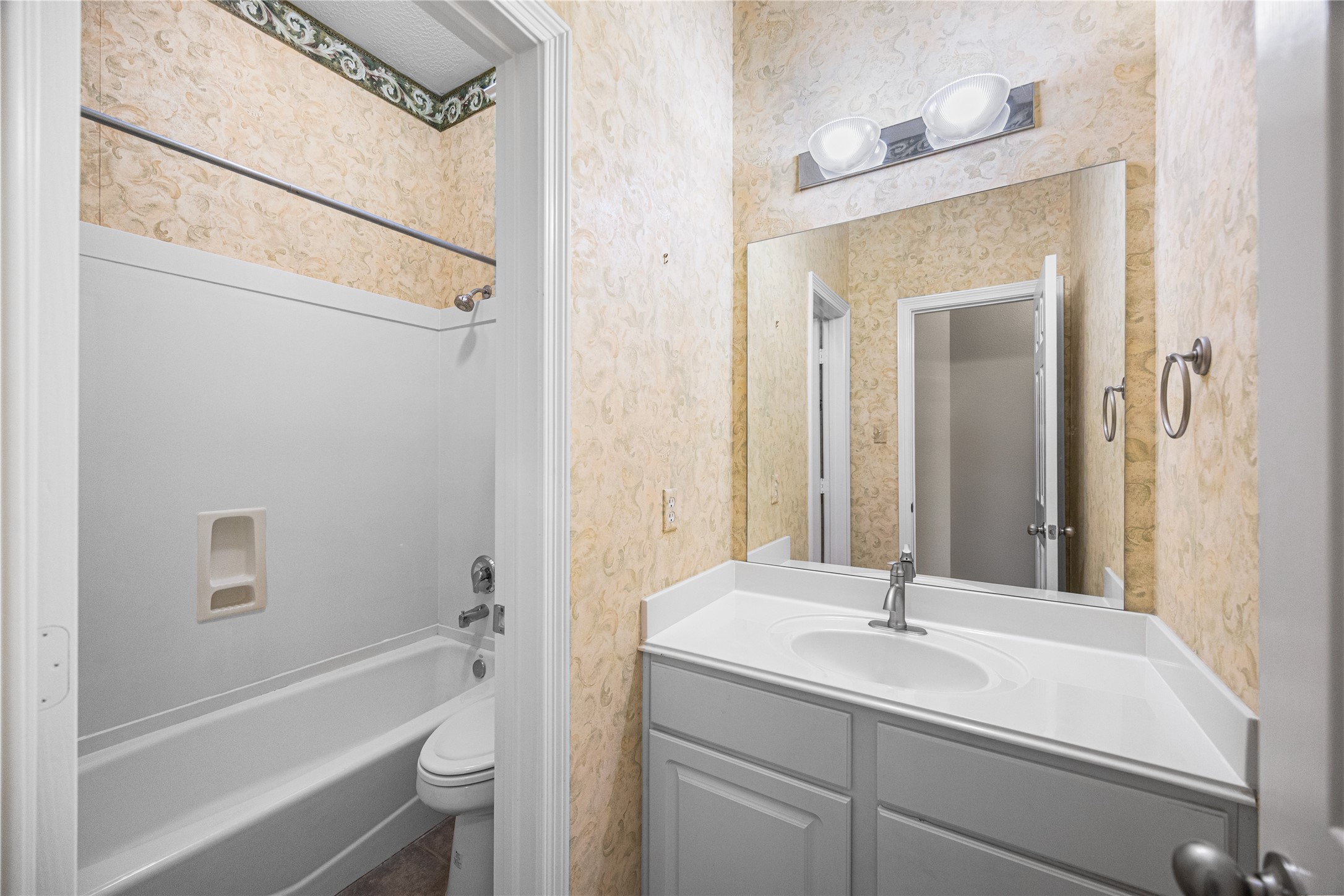 12755 Mill Ridge Drive, Unit 703 Cypress, TX 77429 - Photo 26 of 31 a bathroom with a tub sink vanity mirror and toilet