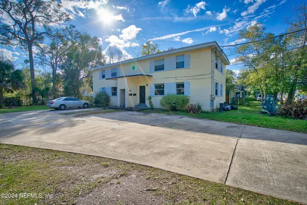 a front view of a house with a yard and trees
