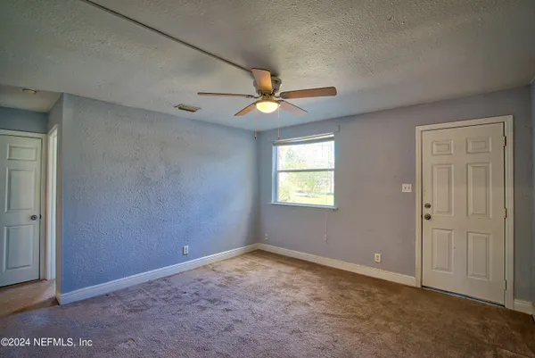 an empty room with closet and a ceiling fan