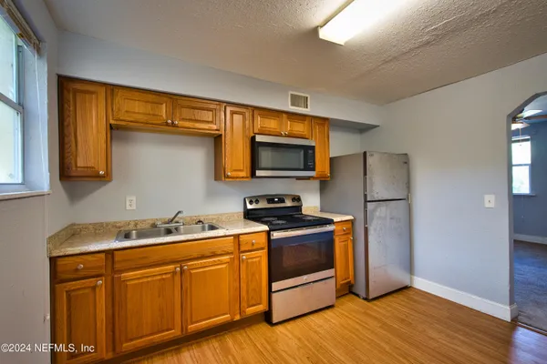 a kitchen with stainless steel appliances granite countertop a sink stove and refrigerator