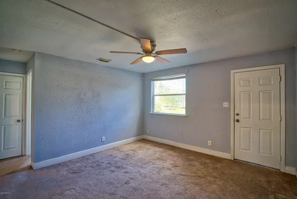 an empty room with closet and a ceiling fan