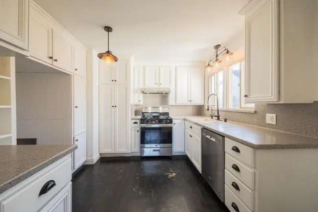 a kitchen with stainless steel appliances a stove a sink and a refrigerator
