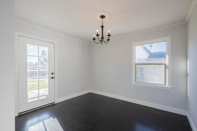 an empty room with wooden floor windows and closet
