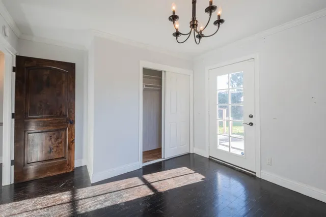 a view of empty room with wooden floor and window