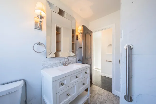 a bathroom with a double vanity sink mirror and toilet