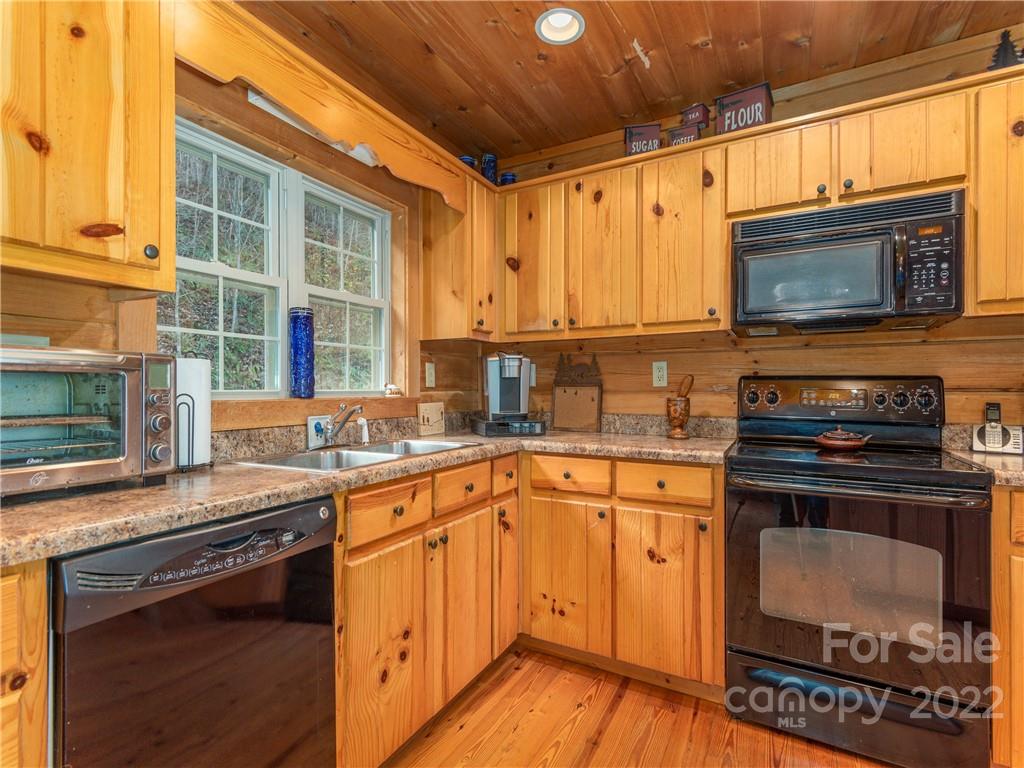839 Price Town Road Clyde, NC 28721 - Photo 12 of 27 a kitchen with stainless steel appliances a stove a sink and a microwave