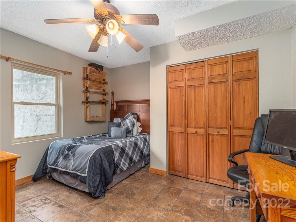 839 Price Town Road Clyde, NC 28721 - Photo 23 of 27 a bedroom with a bed and a chandelier