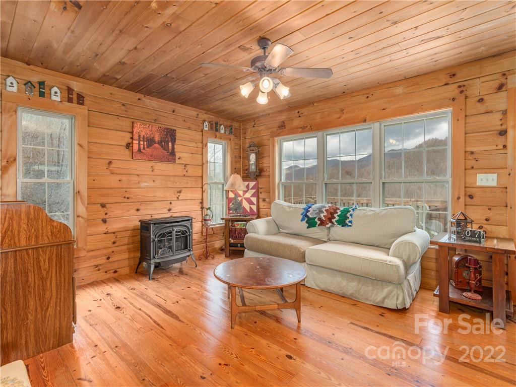 839 Price Town Road Clyde, NC 28721 - Photo 5 of 27 a living room with furniture a fireplace and a table
