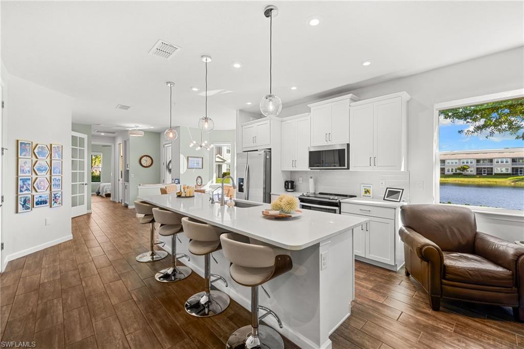 4619 Arboretum Circle, Unit 101 Naples, FL 34112 - Photo 1 of 41 a living room with stainless steel appliances furniture a rug kitchen view and a chandelier