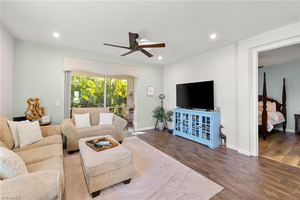4619 Arboretum Circle, Unit 101 Naples, FL 34112 - Photo 14 of 41 a living room with furniture and a flat screen tv