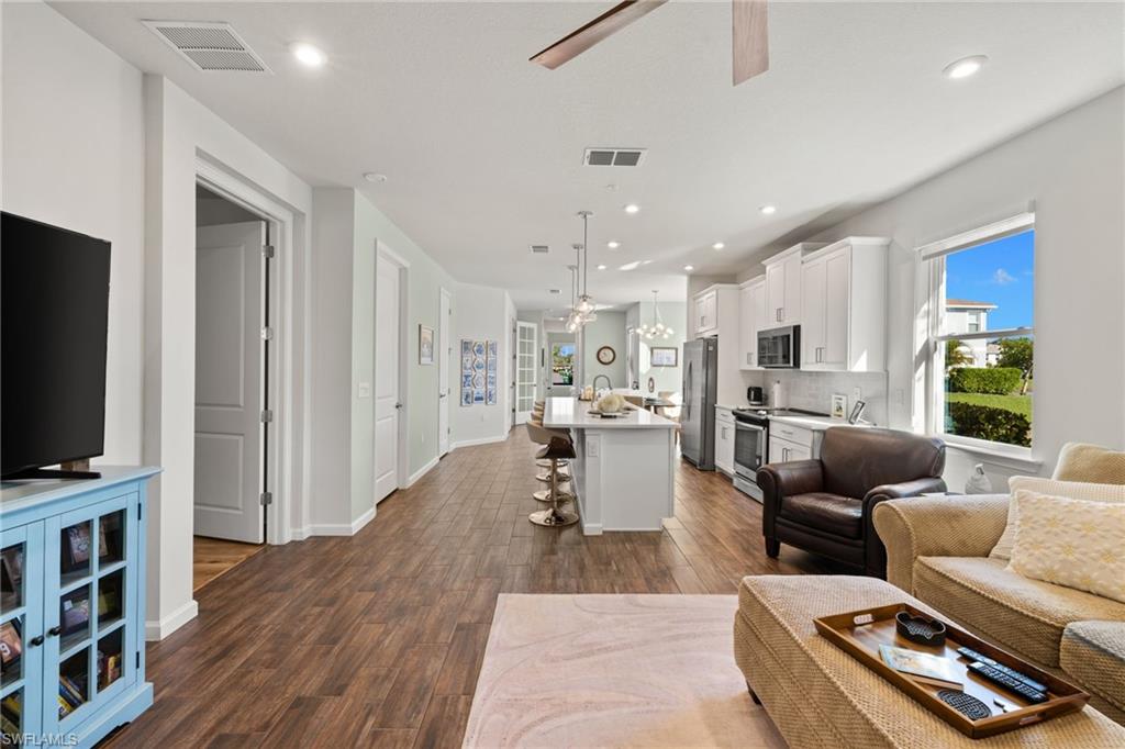 4619 Arboretum Circle, Unit 101 Naples, FL 34112 - Photo 16 of 41 a living room with furniture and a flat screen tv