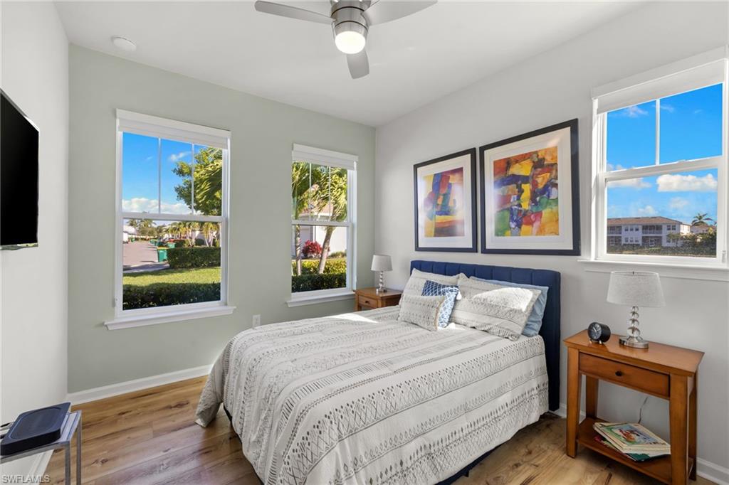 4619 Arboretum Circle, Unit 101 Naples, FL 34112 - Photo 20 of 41 a bedroom with a bed and a painting on the wall