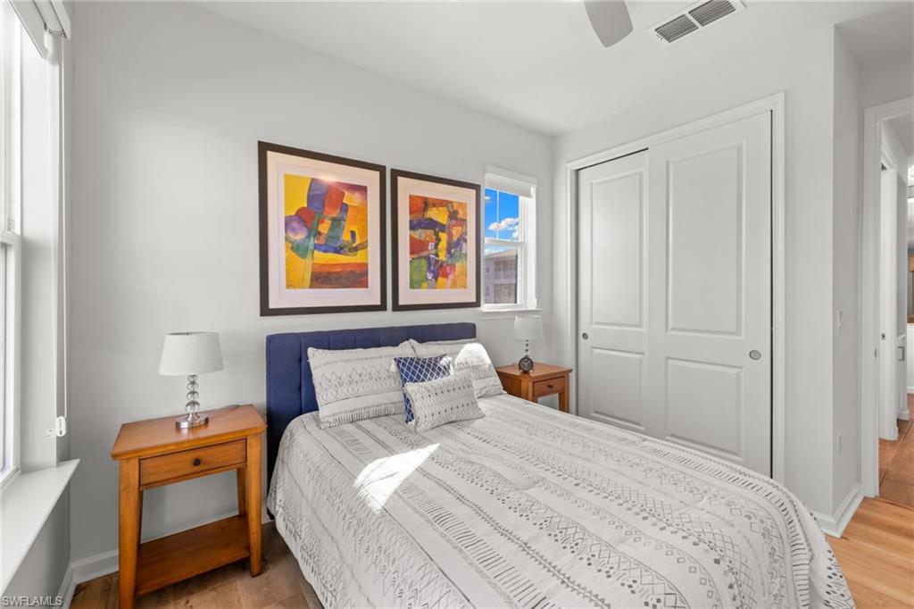 4619 Arboretum Circle, Unit 101 Naples, FL 34112 - Photo 21 of 41 a bedroom with a bed and wooden floor