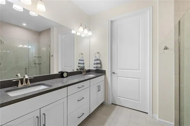 a bathroom with double sink and a mirror