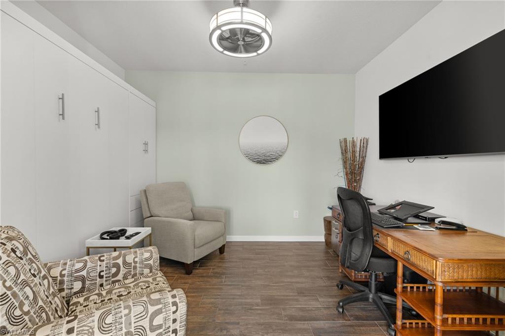 4619 Arboretum Circle, Unit 101 Naples, FL 34112 - Photo 32 of 41 a living room with furniture and a flat screen tv