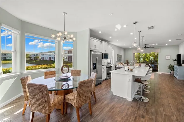 a dining room with furniture a chandelier and wooden floor