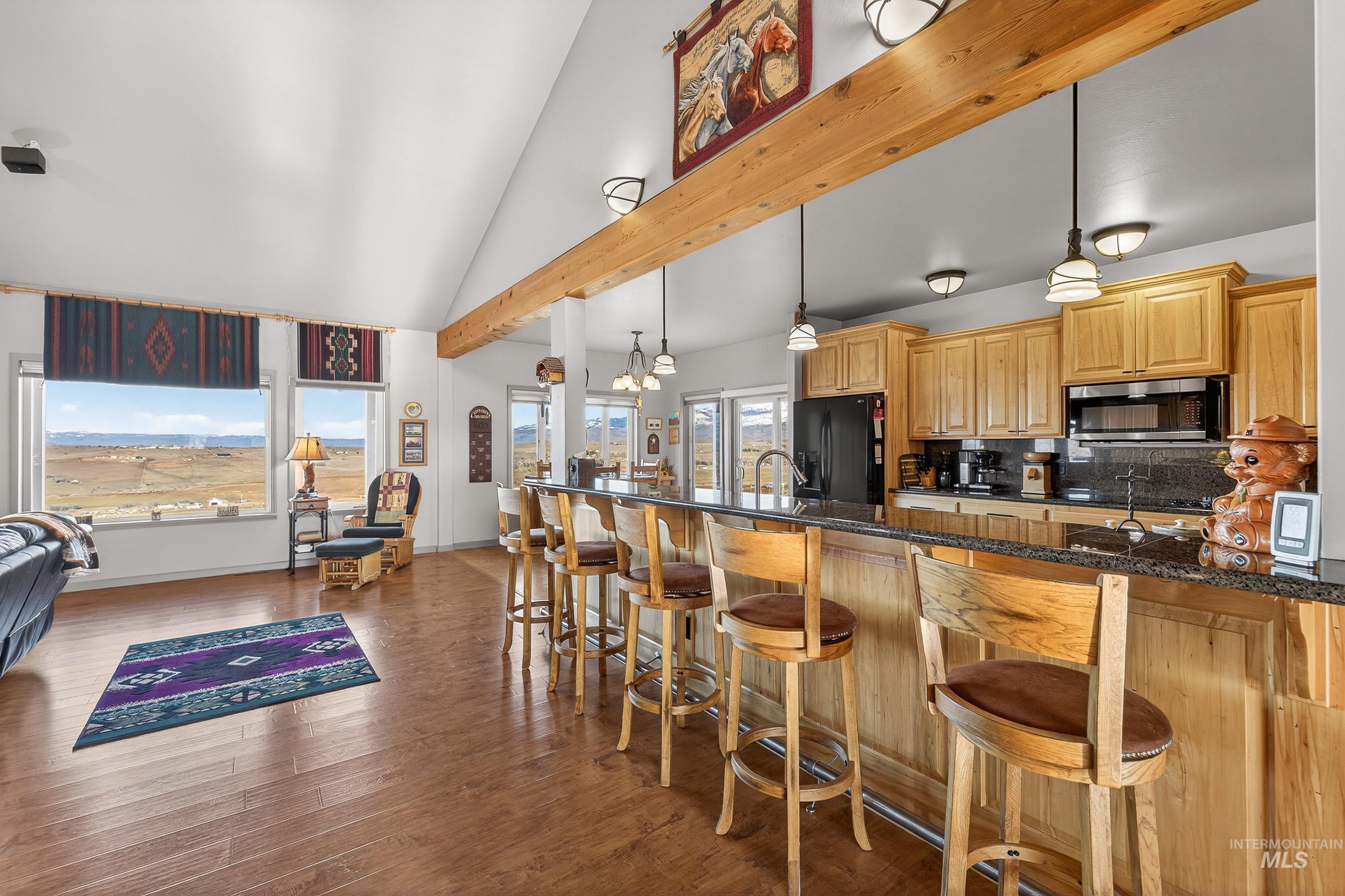 2195 Kilborn Lane Mesa, ID 83643 - Photo 10 of 50 Kitchen with a kitchen breakfast bar, a chandelier, hanging light fixtures, dark stone countertops, and decorative backsplash