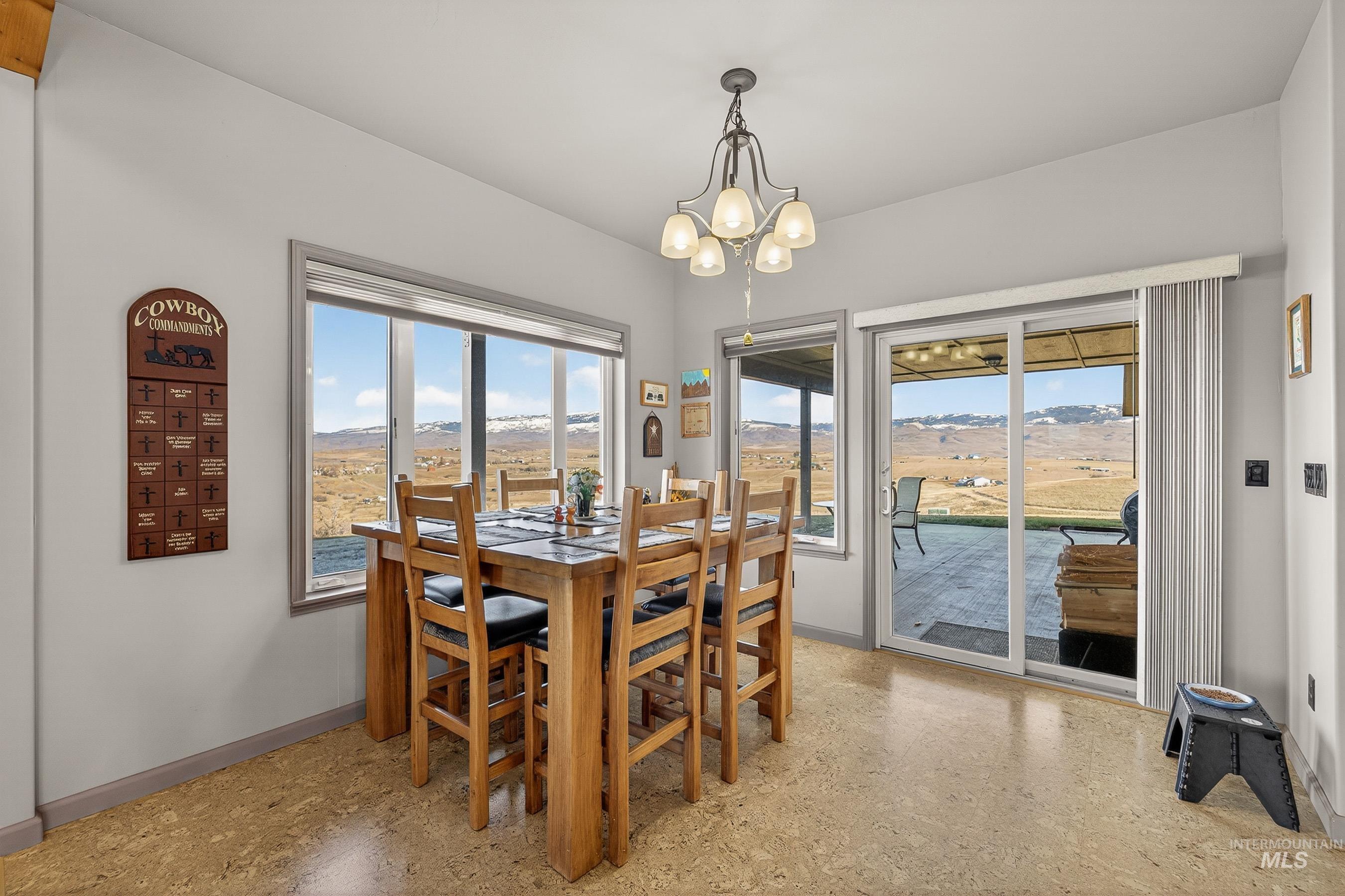 2195 Kilborn Lane Mesa, ID 83643 - Photo 12 of 50 Dining area with a chandelier, a mountain view, and dark speckled floor